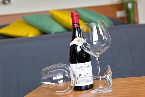 una bottiglia di vino seduta accanto a un bicchiere di vino di Hotel 't Zwaantje a Lichtenvoorde