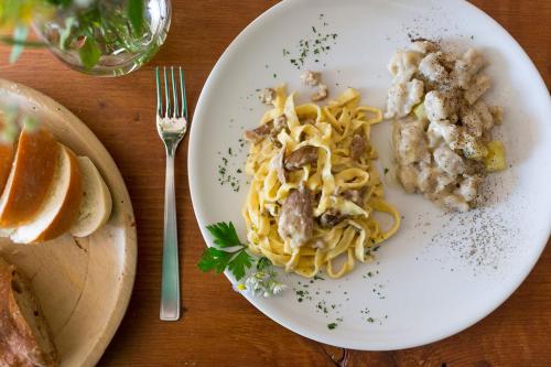 a white plate of food with pasta and meat at Rifugio Uschione in Chiavenna