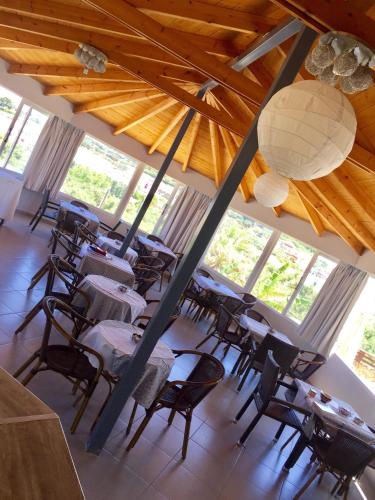 a group of tables and chairs in a room with windows at Zante Calinica Hotel in Tsilivi