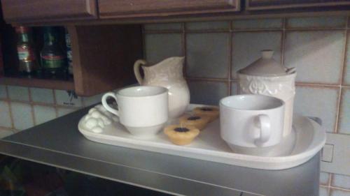 a shelf with two coffee cups and donuts on it at La Bouganville e Il Gelsomino in Pietrasanta
