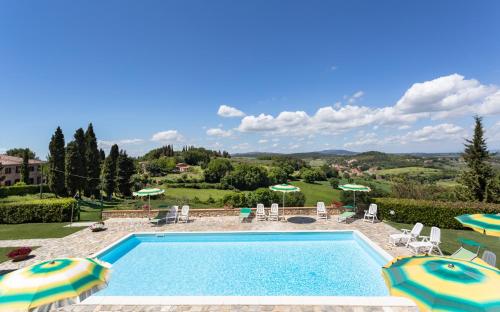 a swimming pool with chairs and umbrellas in a yard at Monti 1824 - Apartments & Cottages in Casole dʼElsa