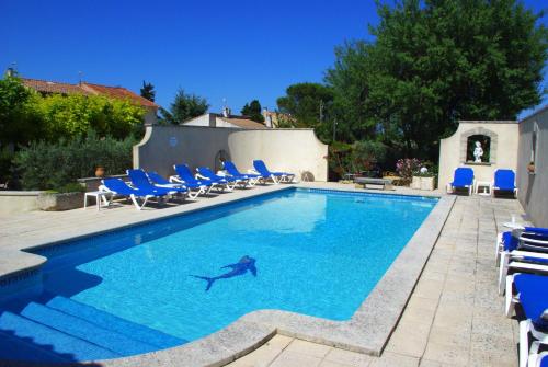 - une piscine avec des chaises et un requin dans l'eau dans l'établissement Gite le Mas de l'Amandier, à Saint-Saturnin-lès-Avignon