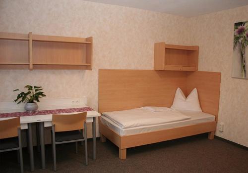 バート・イシュルにあるホテル ソマーハウスのベッドルーム1室(ベッド1台、テーブル、デスク付)