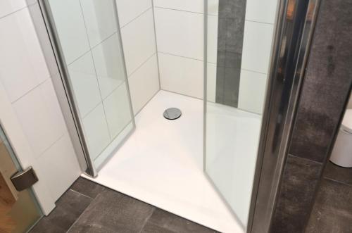 a shower with a glass door with a drain at Gästehaus Guntersblum in Guntersblum