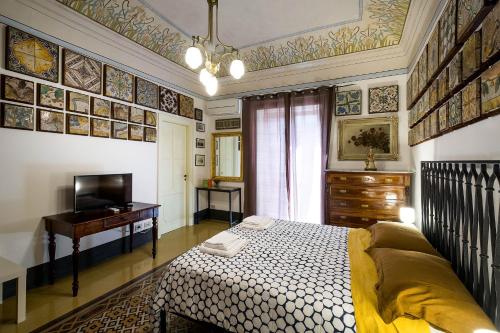 a bedroom with a bed and a desk and a television at Stanze al Genio B&B in Palermo