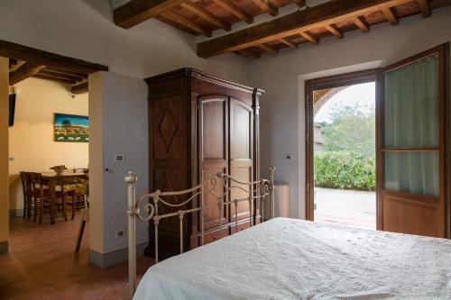 una camera con letto e porta di accesso a un patio di Conca d'Oro a Foiano della Chiana
