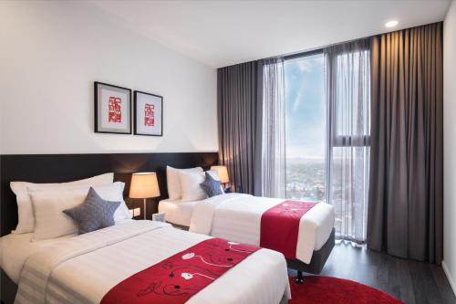 a hotel room with two beds and a large window at Somerset West Point Hanoi in Hanoi