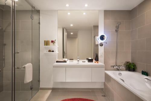 uma casa de banho com uma banheira, um lavatório e um chuveiro em Somerset West Point Hanoi em Hanói