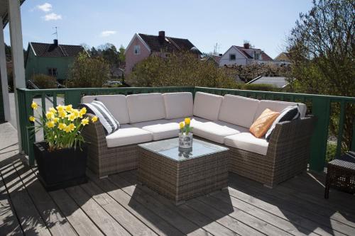 a white couch sitting on a deck with a table at Maude´s Hotel Enskede Stockholm in Stockholm