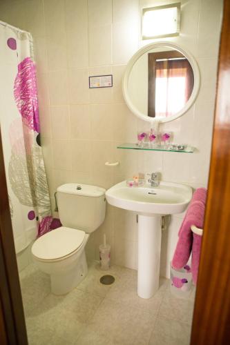 a bathroom with a sink and a toilet and a mirror at Hotel Madrid in Santiago de la Ribera