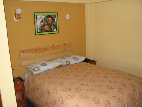 a bedroom with a bed and a picture on the wall at Morales Guest House in Huaraz