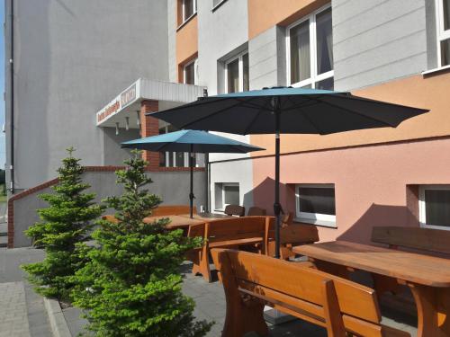 a group of tables and umbrellas on a patio at Centrum Konferencyjne Brancon in Babimost