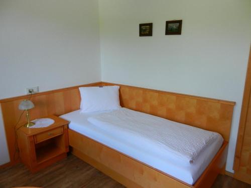 a small bedroom with a bed and a night stand at Pension Apartment Hödner in Ebbs