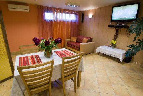 a living room with a table with a vase of flowers at Arciau Juros in Palanga
