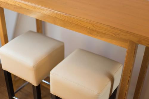 two white stools sitting under a wooden table at Beautiful View Of Sarajevo Center in Sarajevo