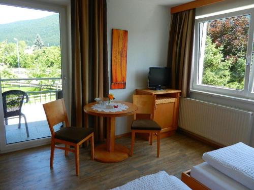 a room with a table and chairs and a balcony at Pension Apartment Hödner in Ebbs