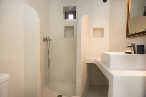 a white bathroom with a shower and a sink at Moustafa Stone House in Emporeiós