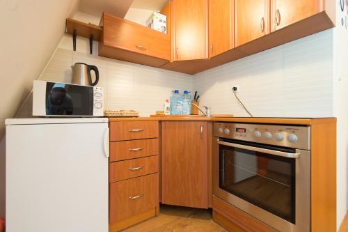 a small kitchen with wooden cabinets and a microwave at Beautiful View Of Sarajevo Center in Sarajevo