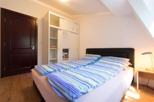 a bed with a striped blanket on it in a bedroom at Beautiful View Of Sarajevo Center in Sarajevo