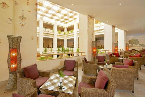 un restaurant avec des chaises et des tables en osier dans le hall dans l'établissement Vincci Safira Palms, à Sangho