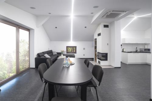 a dining room and living room with a table and chairs at Apartament Iwona in Kobyla Góra