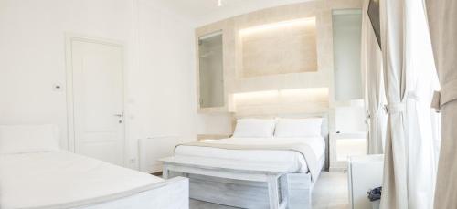 a white bedroom with two beds and a window at Bed & Breakfast AMATI in Fasano