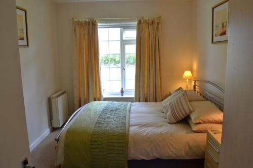 a bedroom with a bed in front of a window at Nanis in Crantock