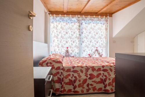 リーヴァ・デル・ガルダにあるLinden Apartmentのベッドルーム1室(窓の前にベッド1台付)