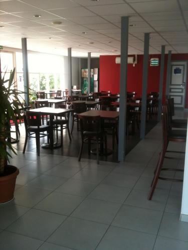 an empty dining room with tables and chairs at initial by balladins Roissy / Saint-Mard in Saint-Mard