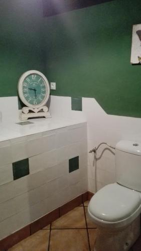 a clock sitting on top of a counter next to a toilet at Albergue De Soba in Lavín