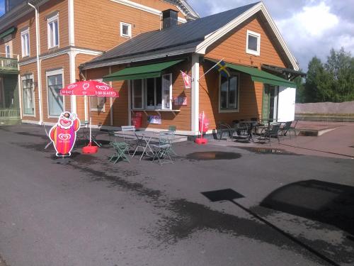 a house with an umbrella and tables and chairs at Orsa Station Bed and Breakfast in Orsa