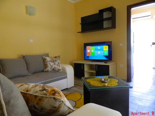 a living room with a couch and a tv at President Bungalows and Apartments in Utjeha