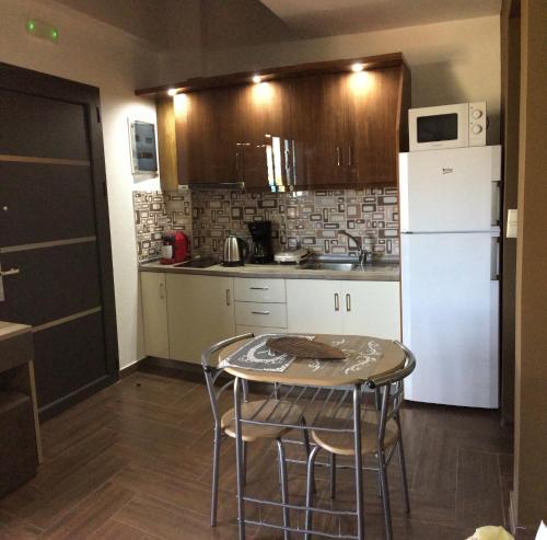 a small kitchen with a table and a white refrigerator at Palmyra Studios in Stavros