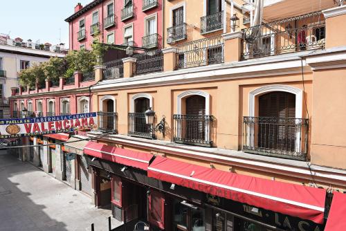 a building with a red awning on a street at Victoria 4 Puerta del Sol in Madrid