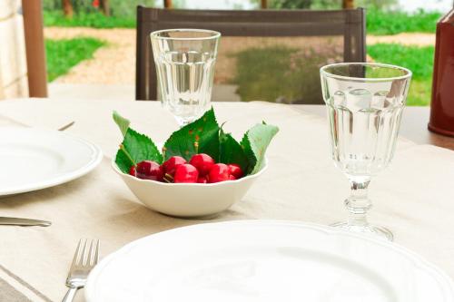 a table with a bowl of berries and two glasses at Cascina Varini in Gargnano