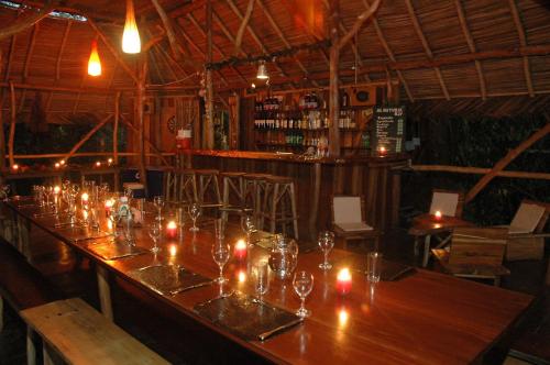 een lange houten tafel in een restaurant met kaarsen erop bij Al Natural Resort in Bocas del Toro