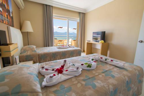 a hotel room with two beds with towels on them at Ephesia Hotel - All Inclusive in Kuşadası