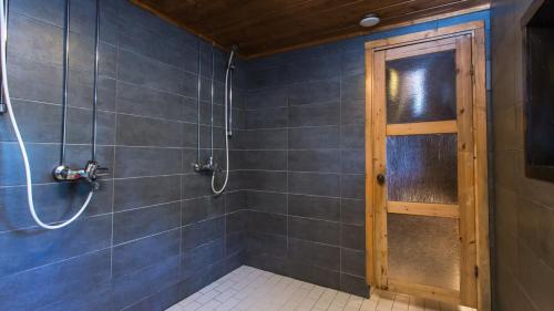bagno con doccia e porta in legno di Riihipiilo a Moksinkylä