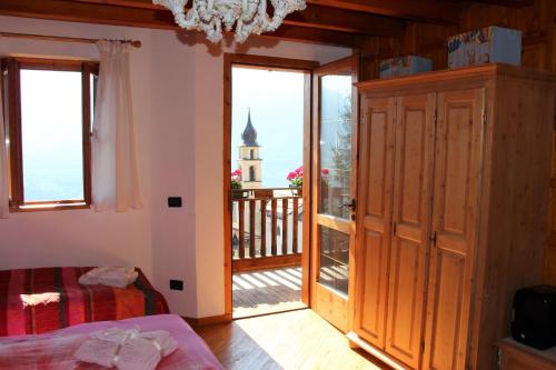 sypialnia z drzwiami prowadzącymi na balkon z kościołem w obiekcie B&B Casa Delle Fate w mieście Campodenno