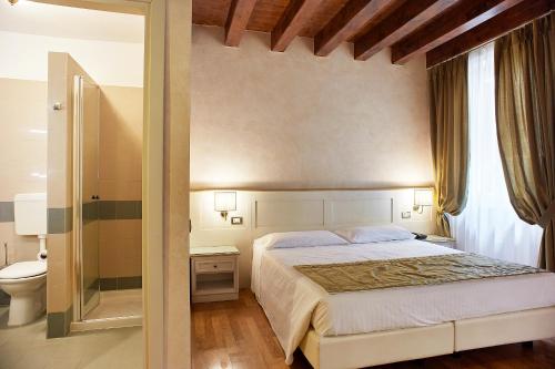 a bedroom with a large bed and a toilet at Albergo Mazzanti in Verona
