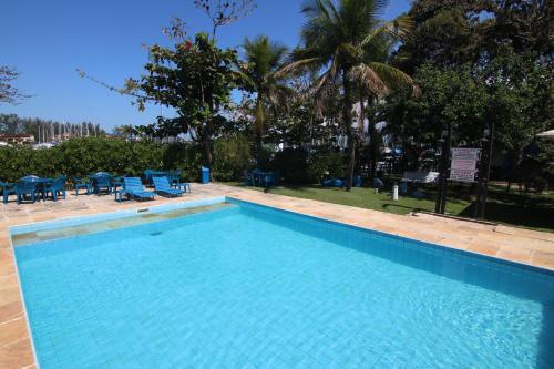 a large swimming pool with blue chairs and trees at Samba Angra dos Reis in Angra dos Reis