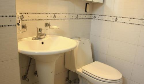 ein weißes Bad mit einem Waschbecken und einem WC in der Unterkunft Eastern Park Pyeongchang in Pyeongchang