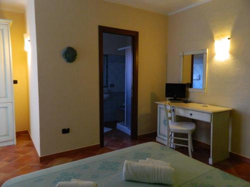 a room with a bed and a desk with a computer at Real B&B Primo Sole in Castelsardo