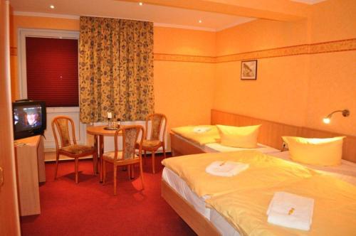 京斯特的住宿－Hotel Rügen Park KG，酒店客房设有两张床和一张桌子。