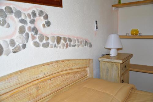 a bedroom with a bed and a lamp on a table at Hotel Valle del Cedrino in Galtellì