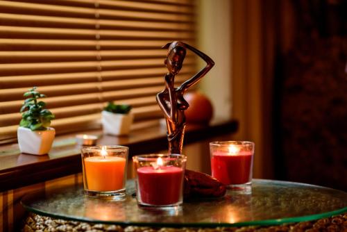 a glass table with three candles and a statue at SPA Hotel Medicus in Varshets