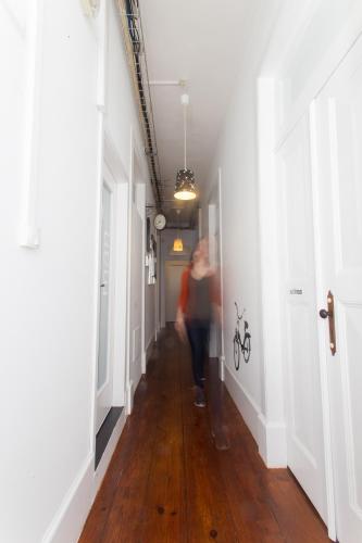 a person walking down a hallway in a house at Aveiro Rossio Hostel in Aveiro