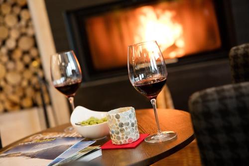 two glasses of wine and a bowl of food on a table at Hotel Zum Mohren in Reutte