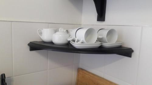 a shelf with plates and cups on a wall at Self-catering Studio, Unit 6 on Krupp in Windhoek