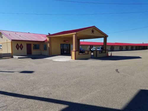 a gas station with a car parked in a parking lot at Executive Inn in Panhandle